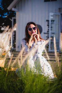 Portrait of young woman in sunglasses on field