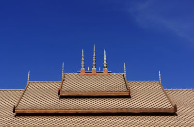 Low angle view of roof of building against blue sky