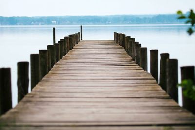 Wooden pier in sea against sky