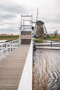 Footbridge over river against sky