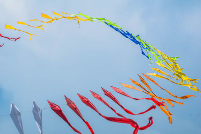 Close-up of multi colored umbrellas against sky