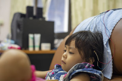 Cute girls with electrodes on head sitting on sofa