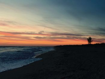 Scenic view of beach against sky during sunset