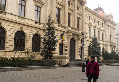 Woman standing by historic building in city