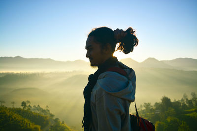Man standing on mountain against sky during sunset