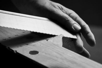 Cropped hand of person shaving wood in workshop