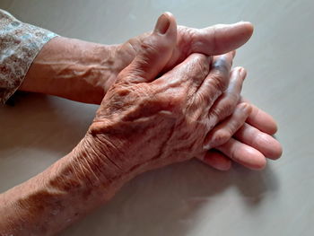 Midsection of old women with hands