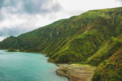 Scenic view of sea and mountains against sky