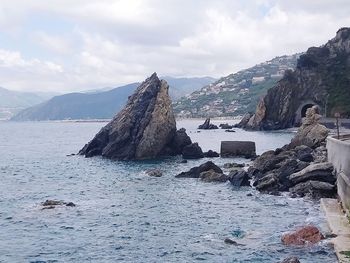 Rock formations by sea against sky