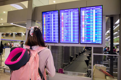 Rear view of woman standing at airport