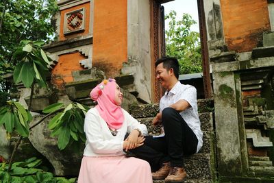 Couple sitting on built structure