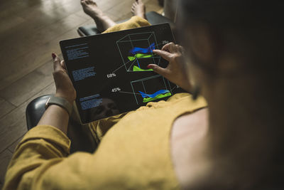 Businesswoman touching diagram on tablet pc screen at home office