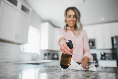 Low angle view of woman cleaning kitchen counter at home