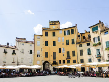 People at outdoor cafe by buildings in town