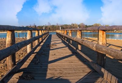 Bridge over calm sea against sky