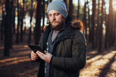 Young man using mobile phone while standing on land