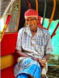 Portrait of man wearing hat sitting outdoors