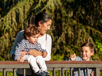 Family by railing against trees