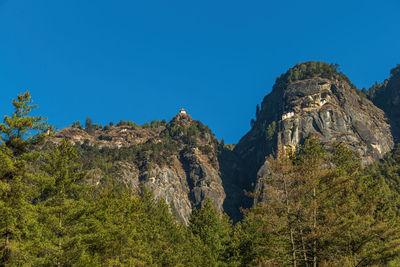 Low angle view of rock formations against clear blue sky