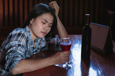 Mid adult man drinking glass on table