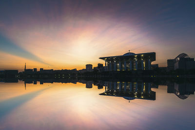 Reflection of buildings in lake during sunset