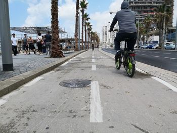 People riding bicycle on road in city