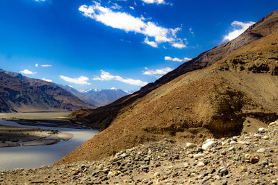 Scenic view of lake and mountains against blue sky