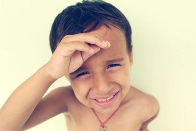 Close-up portrait of a smiling boy over white background