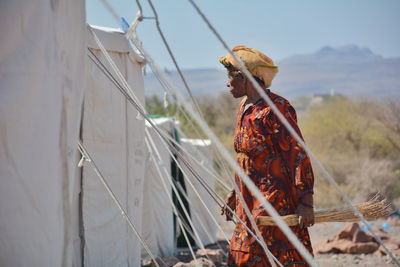 Low angle view of woman standing against sky