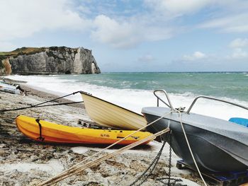 Boat moored on beach against sky