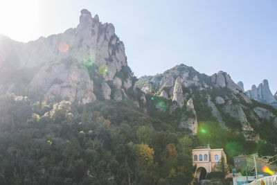Low angle view of rocky mountains during sunny day