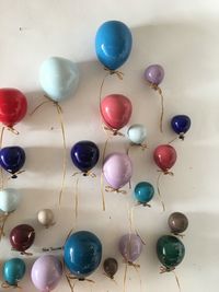 Multi colored balloons hanging on wall