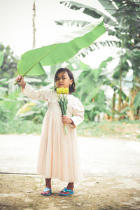 Portrait of woman standing against plants