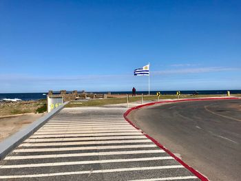 View of road by sea against clear sky