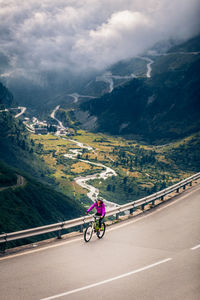 Woman riding bicycle on mountain road