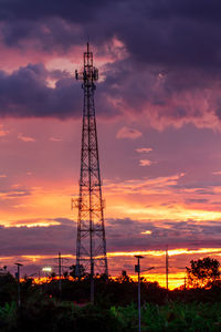 Low angle view of silhouette tower against orange sky