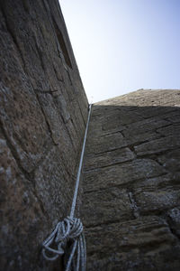Low angle view of rope tied up on wall