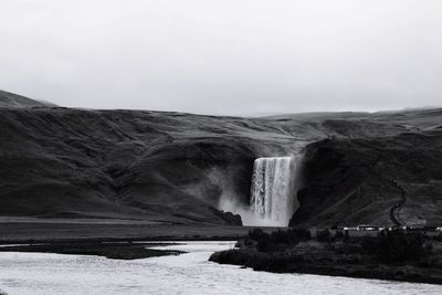 Scenic view of waterfall against sky