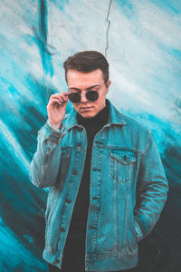 Portrait of young man wearing sunglasses standing outdoors