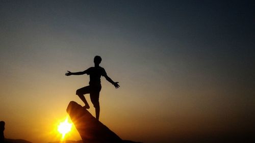 Silhouette of woman against sky during sunset