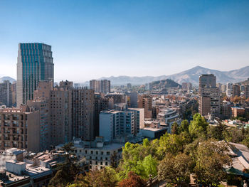 Modern buildings in city against clear blue sky