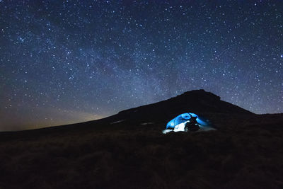 Woman in tent against sky at night