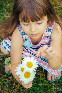 Close-up of young woman sitting on field