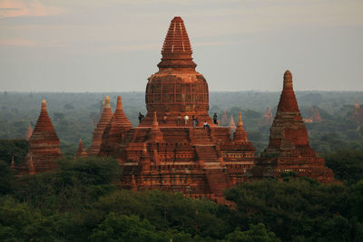 People at stupa against sky