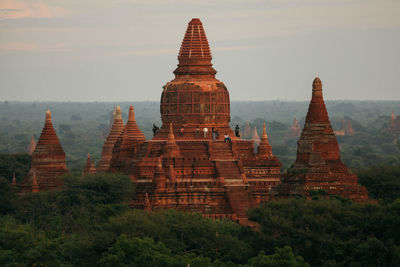 People at stupa against sky