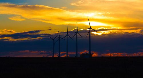 Low angle view of silhouette windmill against sky during sunset