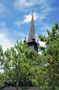 Low angle view of trees and building against sky