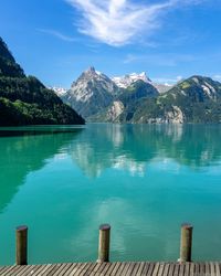 Scenic view of lake by mountains against sky