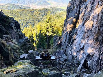 High angle view of people sitting on rock against mountains