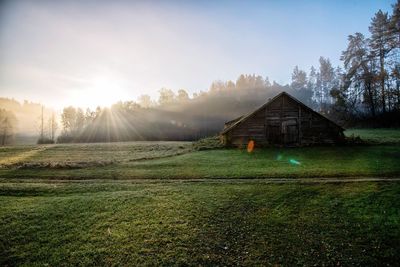 House on field against sky during sunset